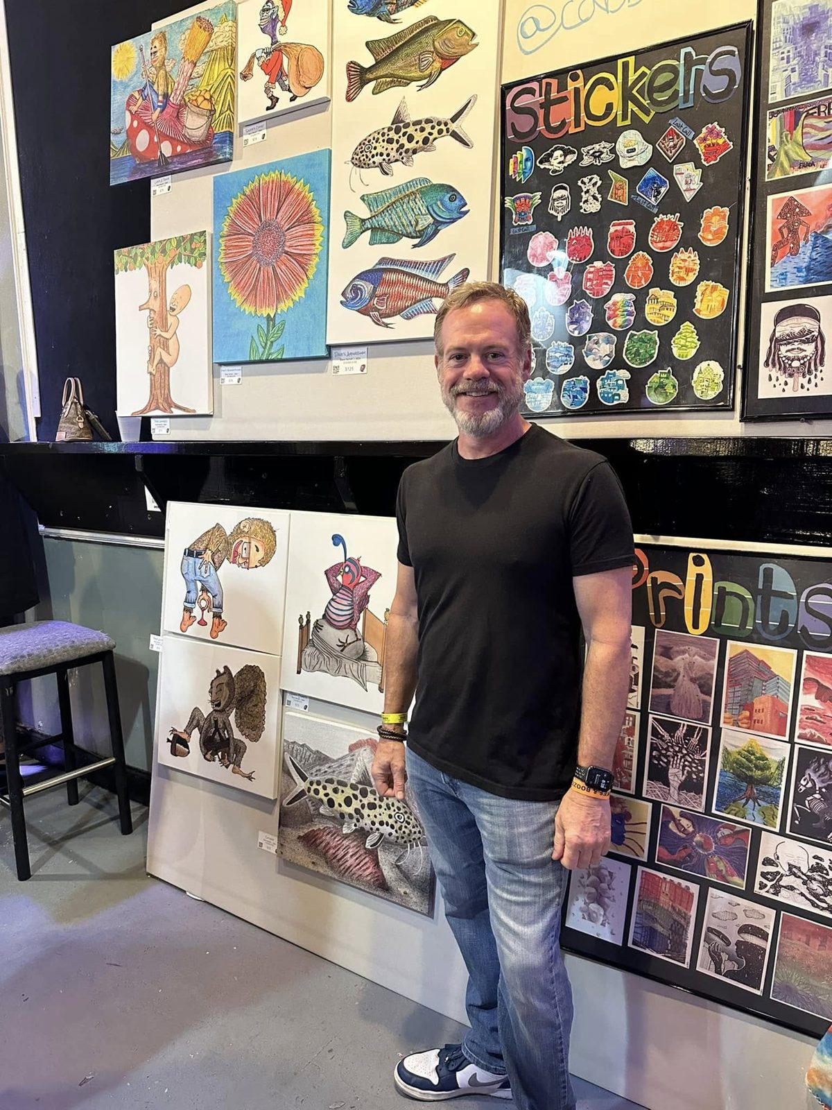 Dave standing beside his drawings at an art show.
