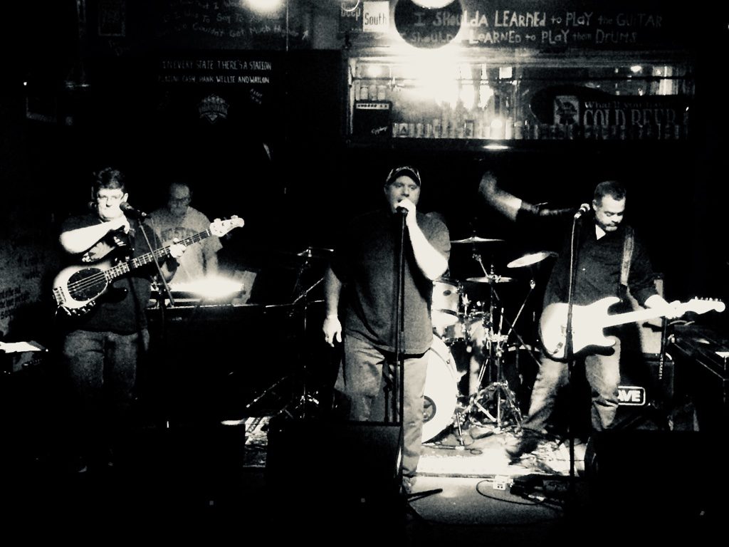 Crave playing in a dark bar, in black and white.