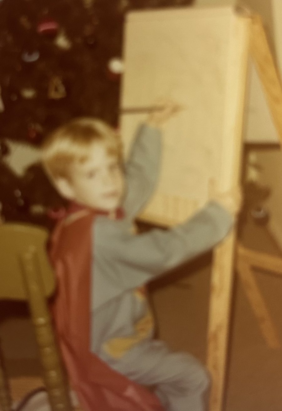 Dave as a boy painting at an easel.