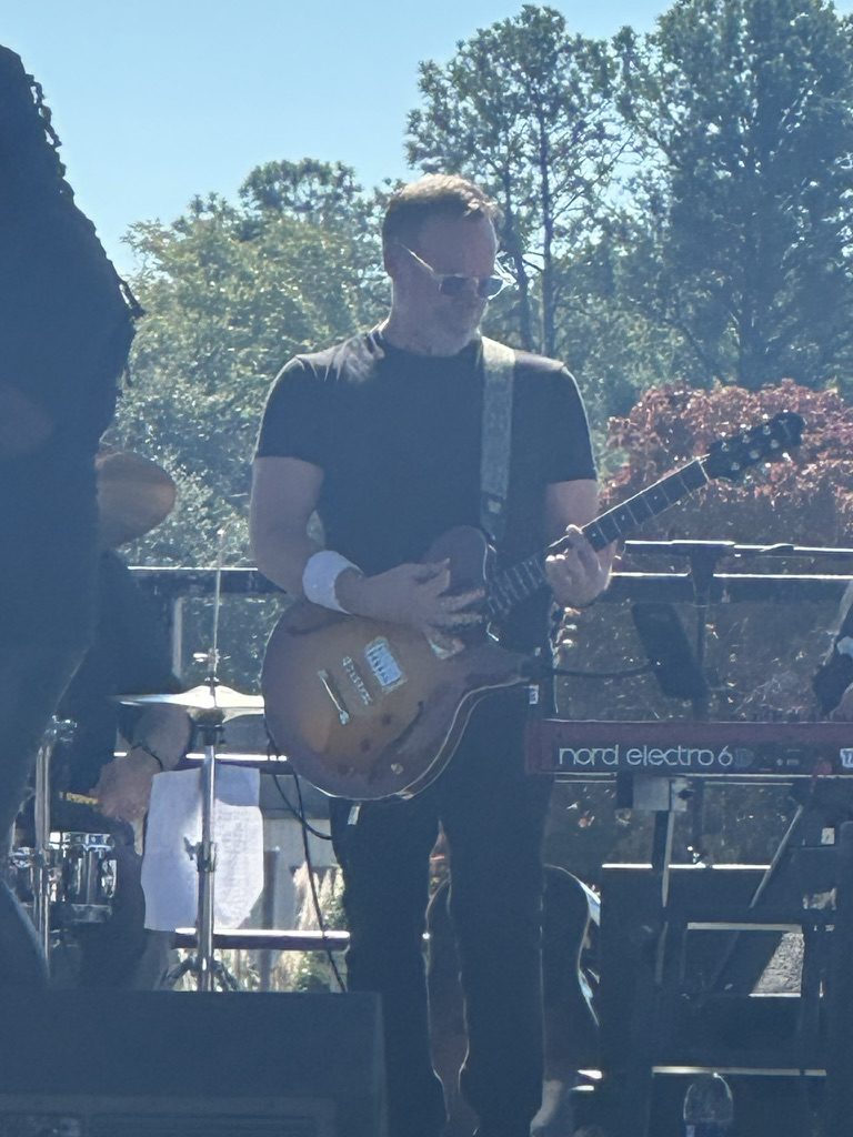 Dave playing guitar on an outdoor stage.