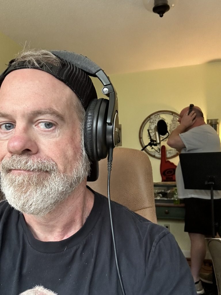 Dave in headphones while Charlie sings behind him.